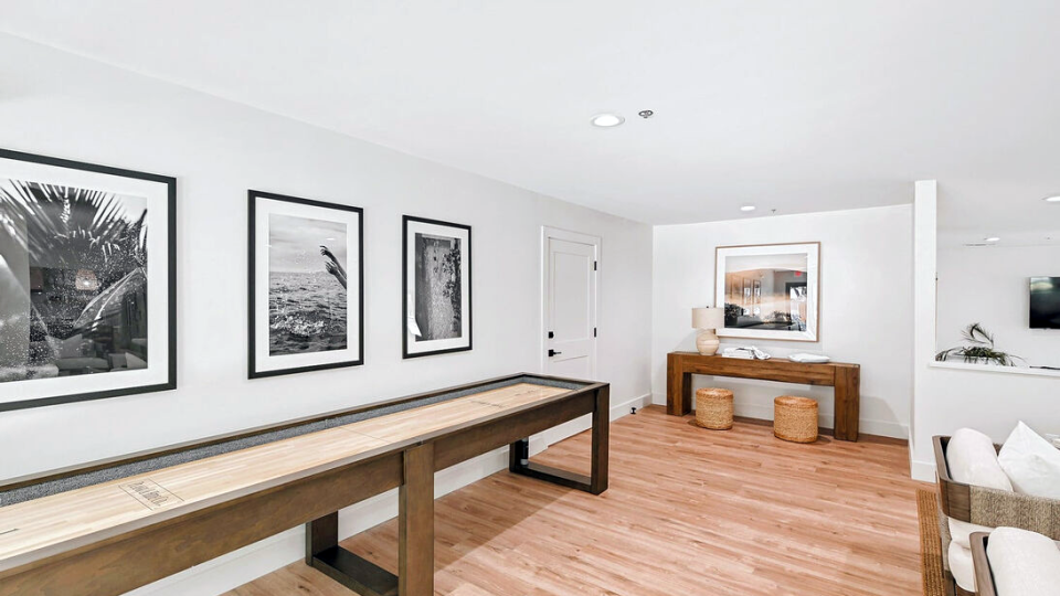 a clean and organized living room with a shuffleboard table at The Landmark At Gleneagles