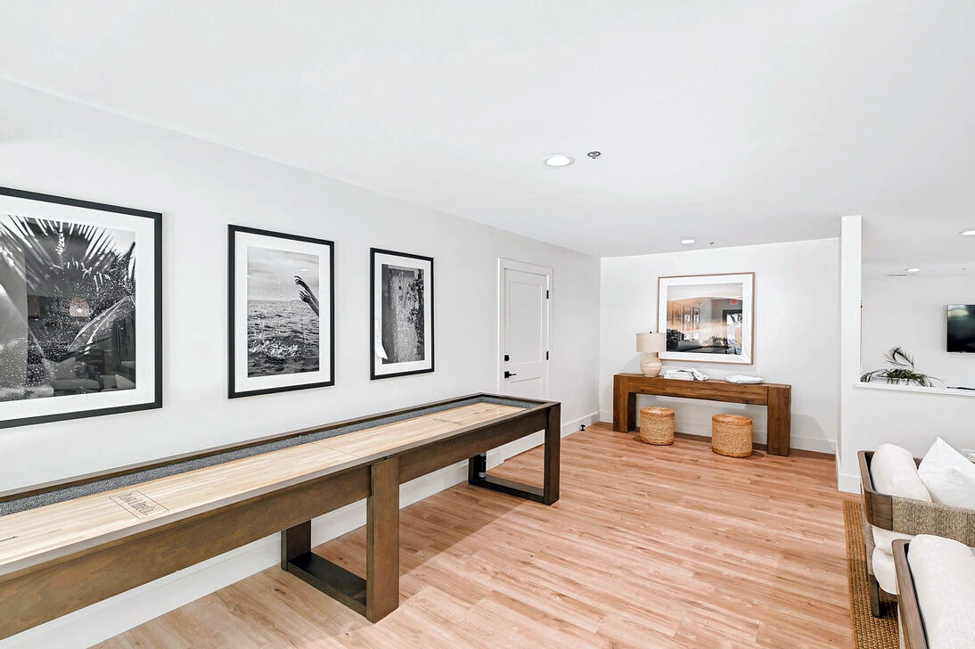 a clean and organized living room with a shuffleboard table at The Landmark At Gleneagles