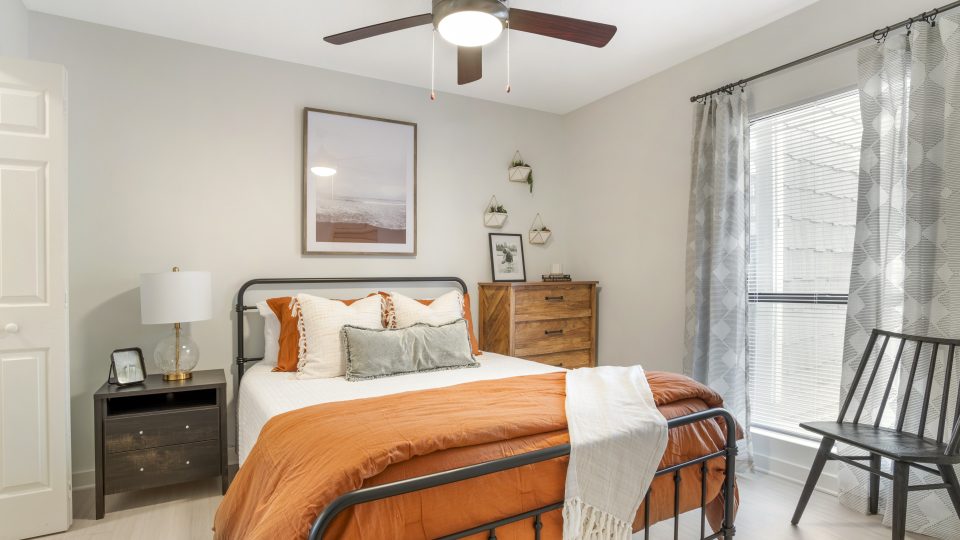 a bedroom with a bed, dresser and ceiling fan at The Monte