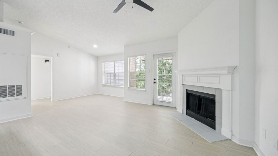 empty living room with white walls and ceiling fan at The  Monte