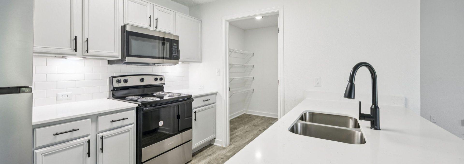a kitchen with stainless steel appliances and white cabinets at The  Monte