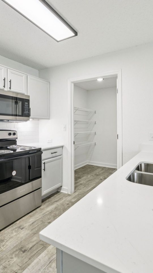 a kitchen with stainless steel appliances and white cabinets at The  Monte
