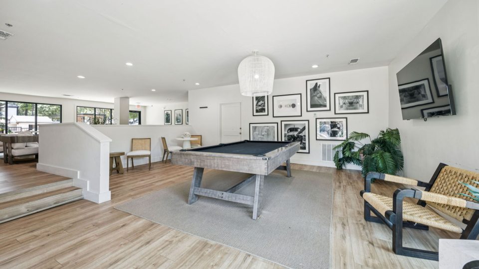 a pool table in a living room with a couch and chairs at The Monte
